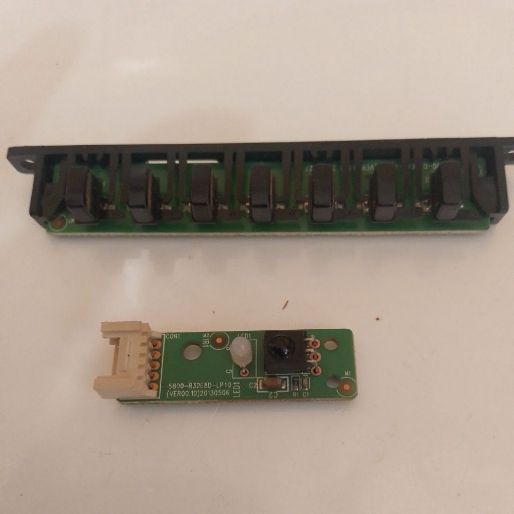 Modul sensor remote (IR receiver) + LED indikator di bagian depan TV Coocaa 32”.