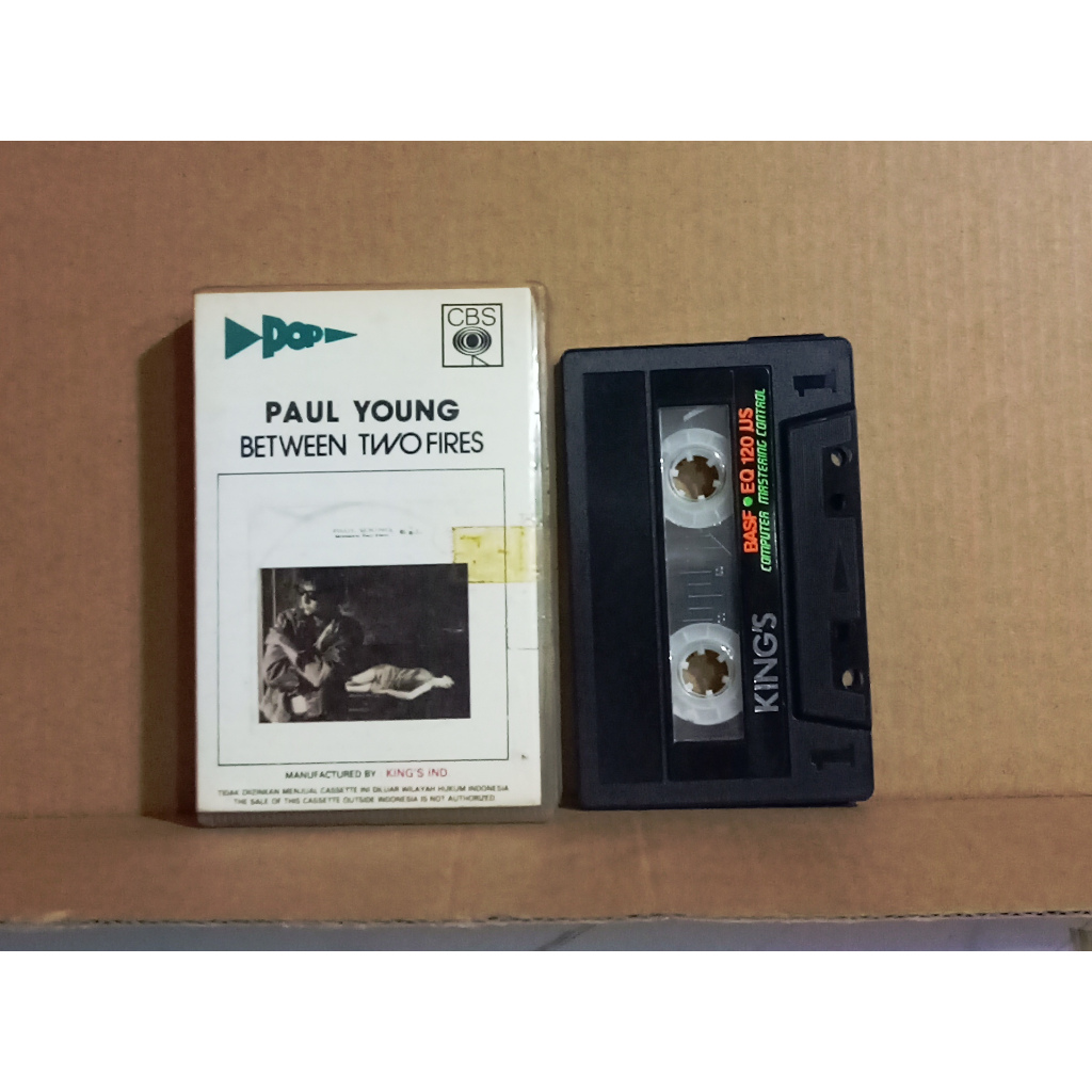 PAUL YOUNG - BETWEEN TWO FIRES - Kaset