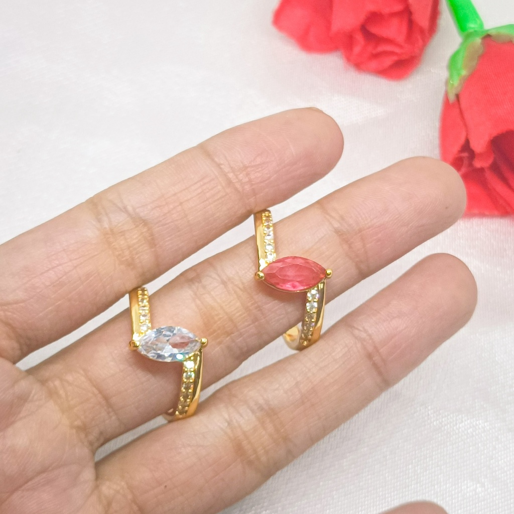 Cincin berlapis emas 24 karat dengan desain unik, dihiasi dengan batu permata besar dan dikelilingi 