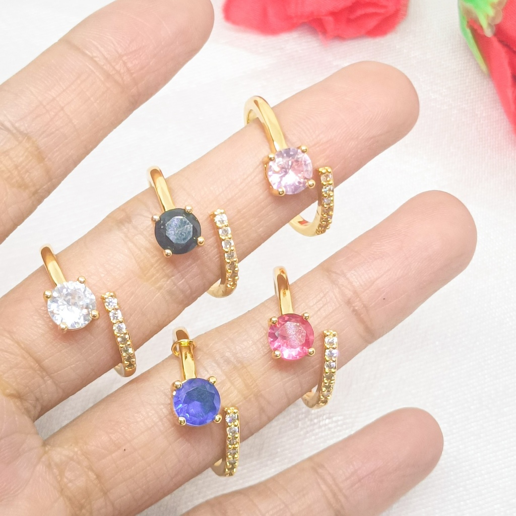 Cincin berlapis emas 24 karat dengan desain unik, dihiasi dengan batu permata besar dan dikelilingi 