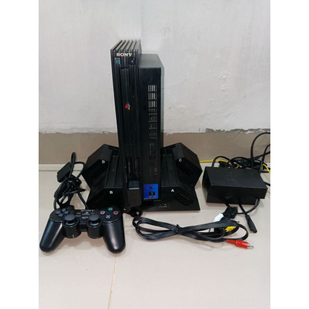 PS2 FAT dengan stand dan satu stick op kondisi normal bisa baca kaset dengan adaptor 110 volt +stand