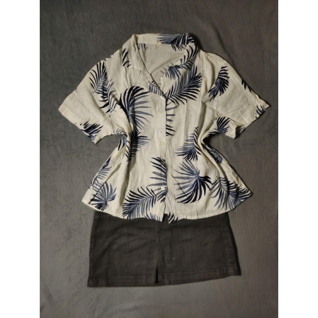 kemeja Hawaii atau kemeja aloha dengan motif daun tropis berwarna putih tulang dan biru tua