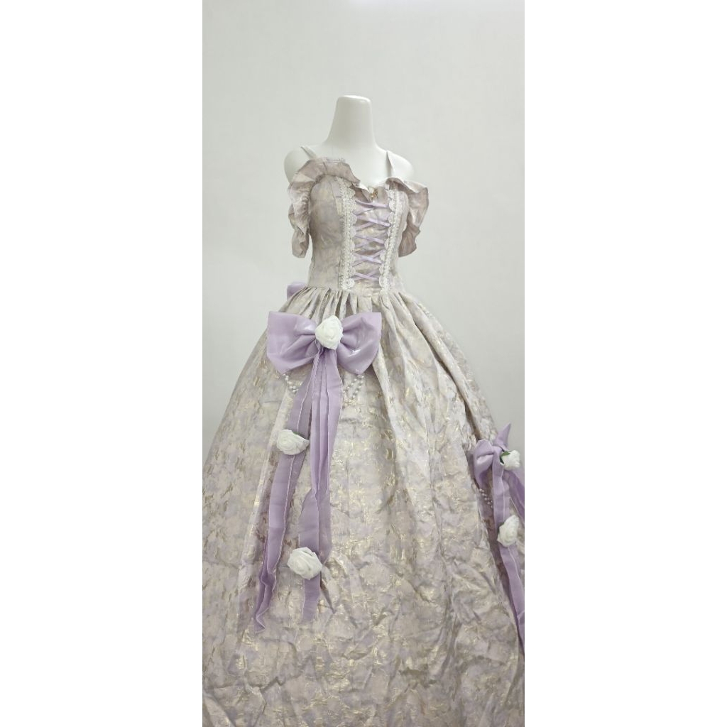 Gaun pesta warna ungu dengan aksesoris bunga