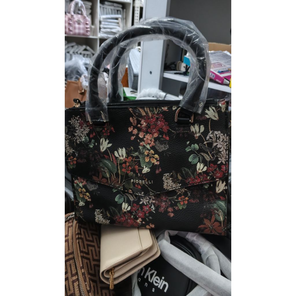 Tas tangan Fiorelli dengan motif bunga multiwarna di atas bahan dasar hitam. 