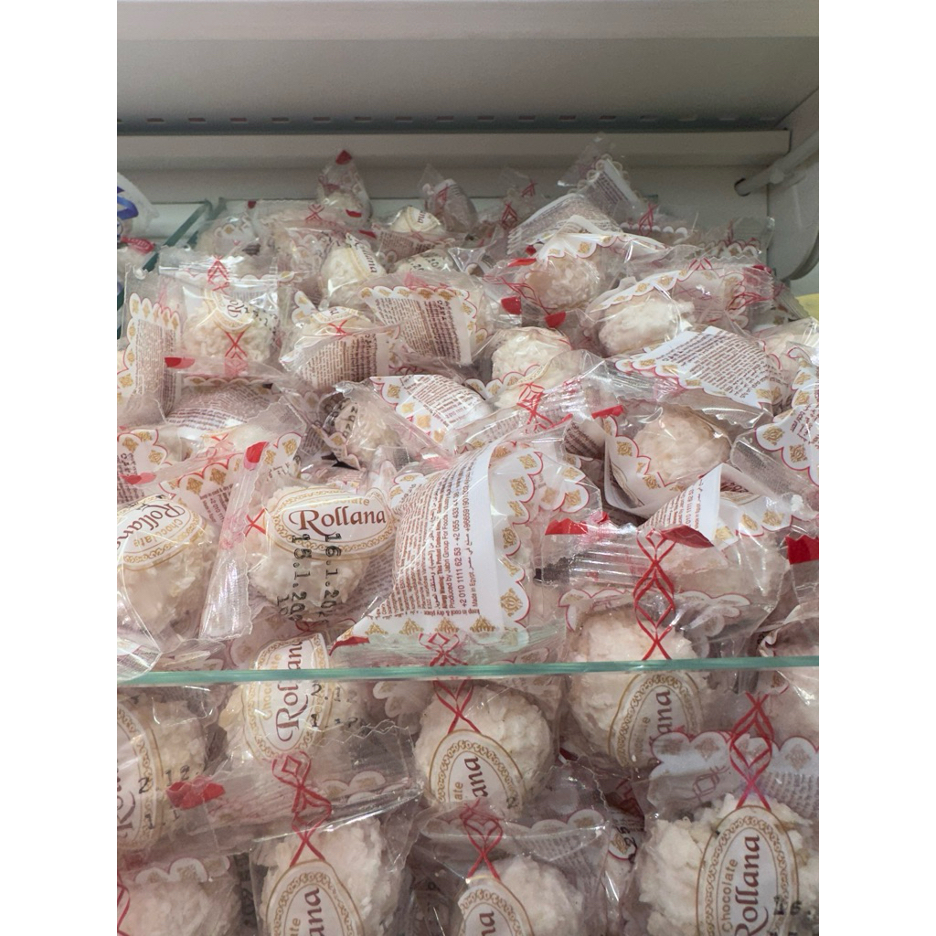Rollana biskuit berisi coklat putih berisi almond dengan butiran kelapa diluarnya