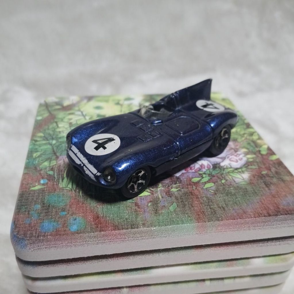 Hot Wheels Jaguar D-Type berwarna biru dengan nomor balap 4.