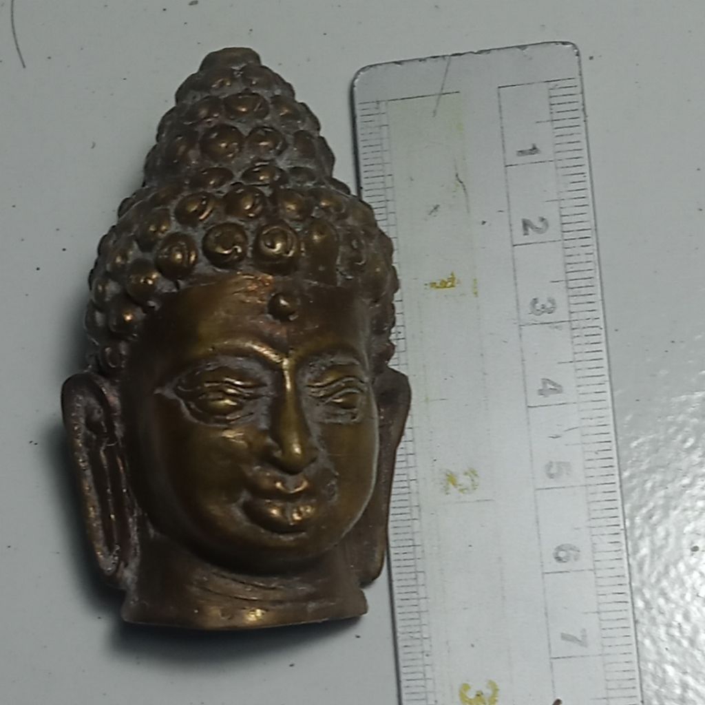 patung kepala Budha. kuningan