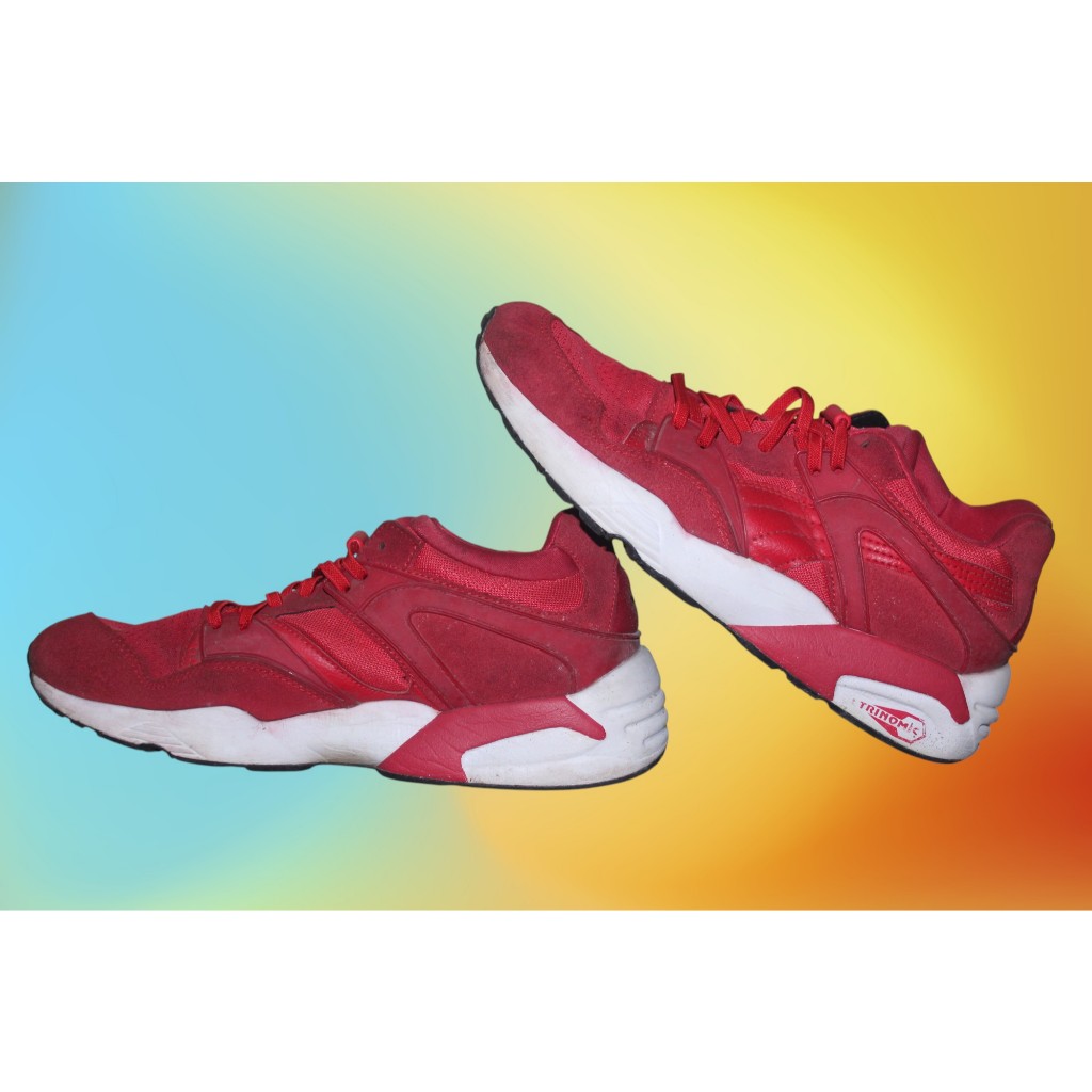 Sepatu ini adalah Puma Trinomic Blaze berwarna merah cerah dengan teknologi bantalan Trinomic yang k
