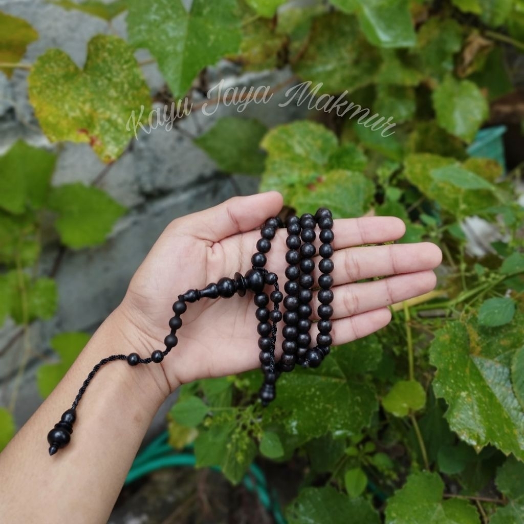 Tasbeh kayu galih kelor hitam isi 99 butir.