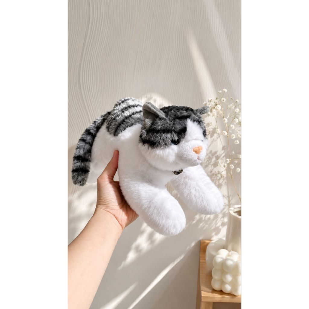 Boneka kucing belang berbaring lying cat