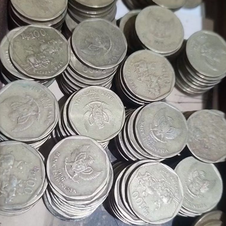 Uang logam kuning 100 rupiah untuk koreksinya gambar karapan sapi