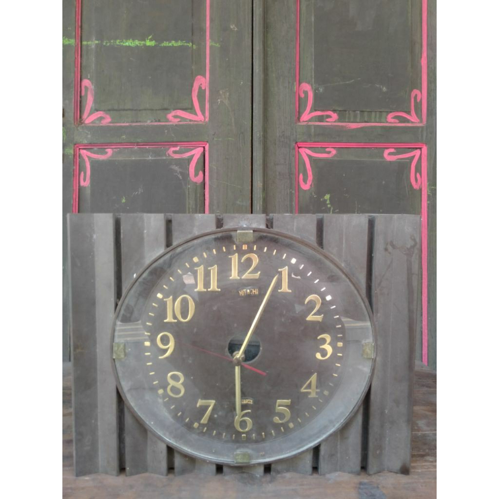 Jam dinding Hitachi dengan bingkai kayu bergaris vertikal khas gaya vintage
