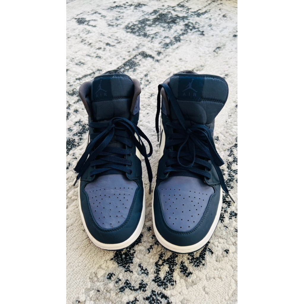 Nike Air Jordan 1 Mid in the 'Obsidian' or 'Sanded Purple' colorway.