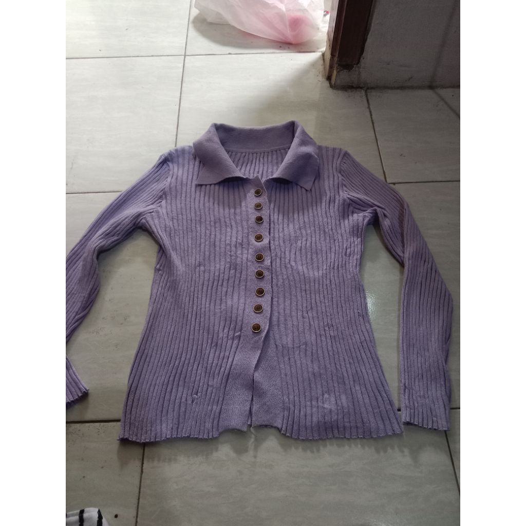 atasan rajut bergaris dengan kancing depan, yang diidentifikasi sebagai Oudre Gochujang Top