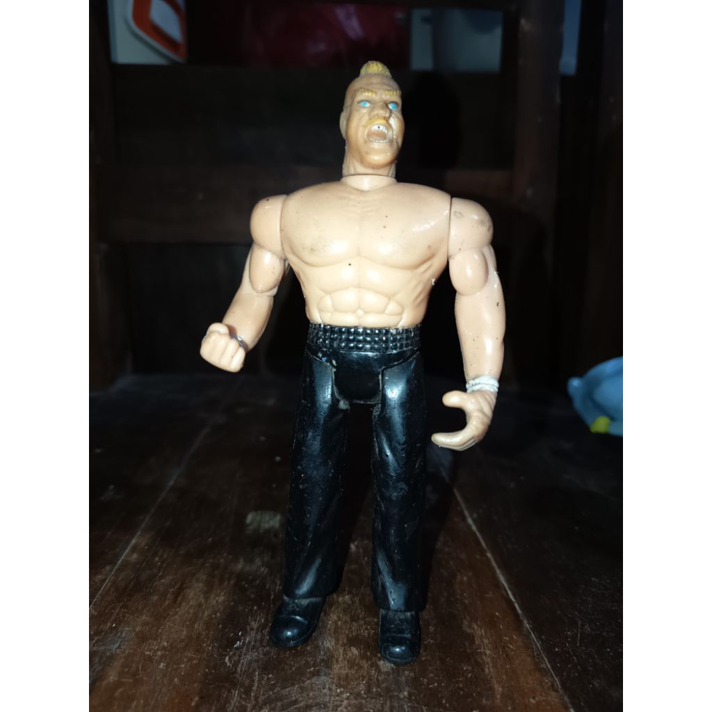 action figure WWE yang menggambarkan pegulat Brock Lesnar, yang memiliki ciri khas rambut pirang jab