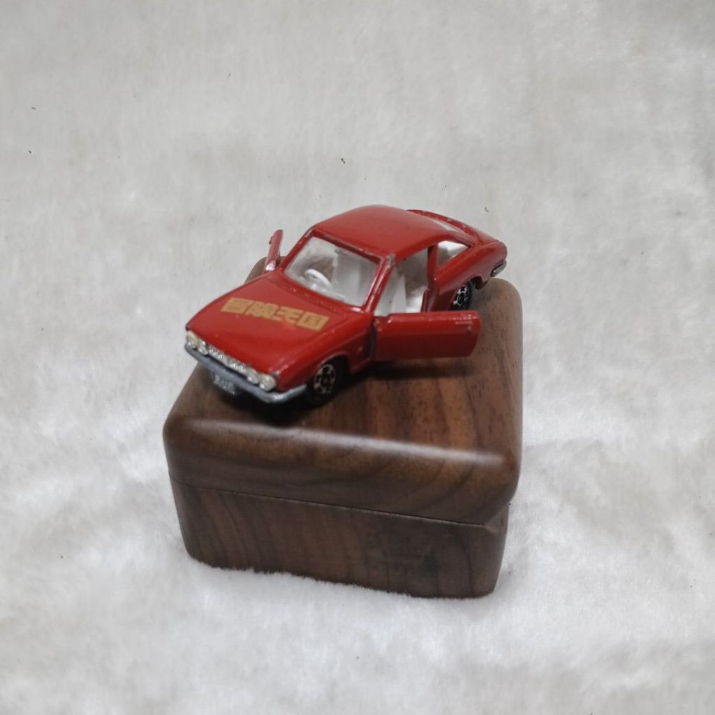 mainan mobil diecast Tomica Isuzu 117 Coupe edisi khusus "Bouken Oukoku" (Kerajaan Petualangan)