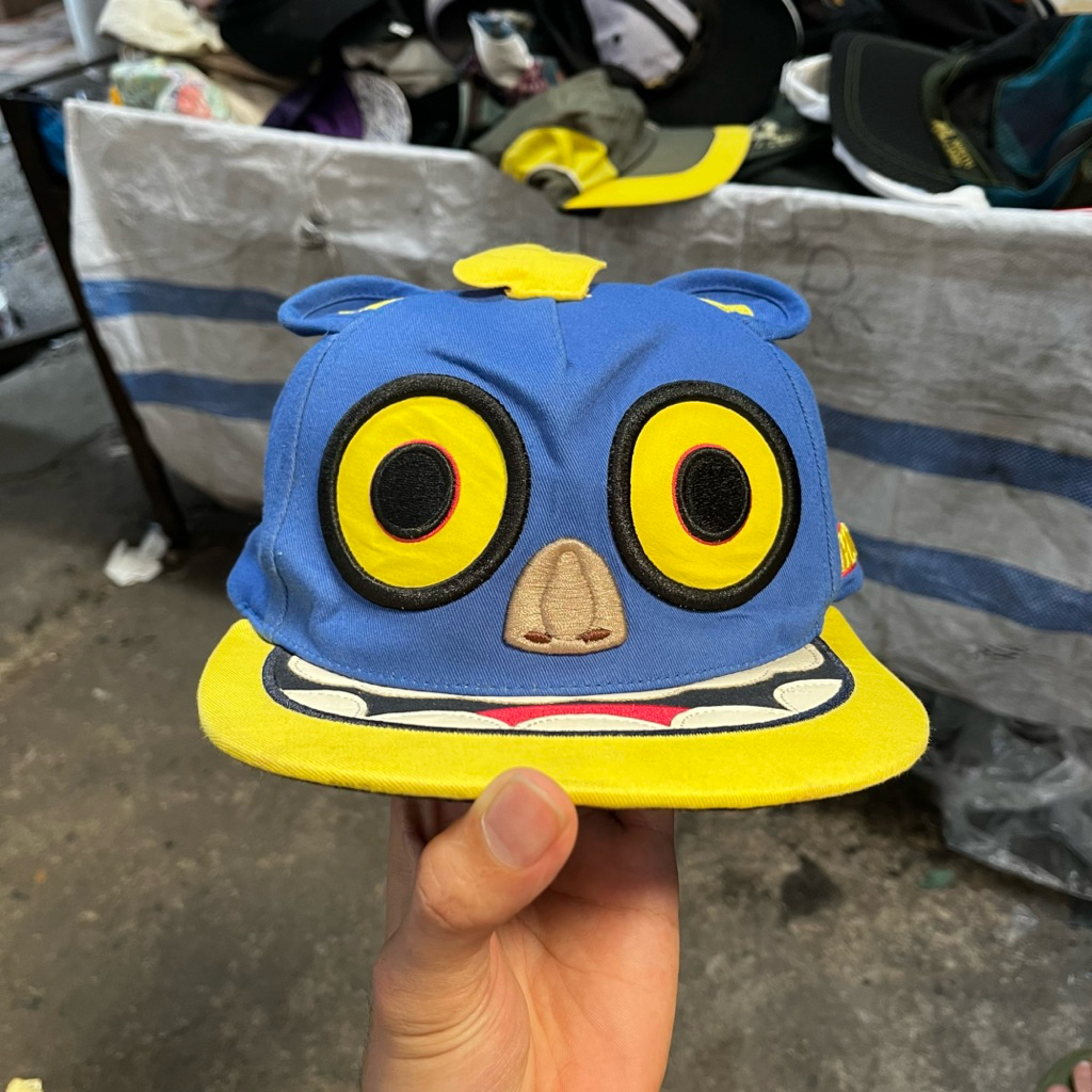 topi dewasa karakter monster Elstinko warna biru dan kuning