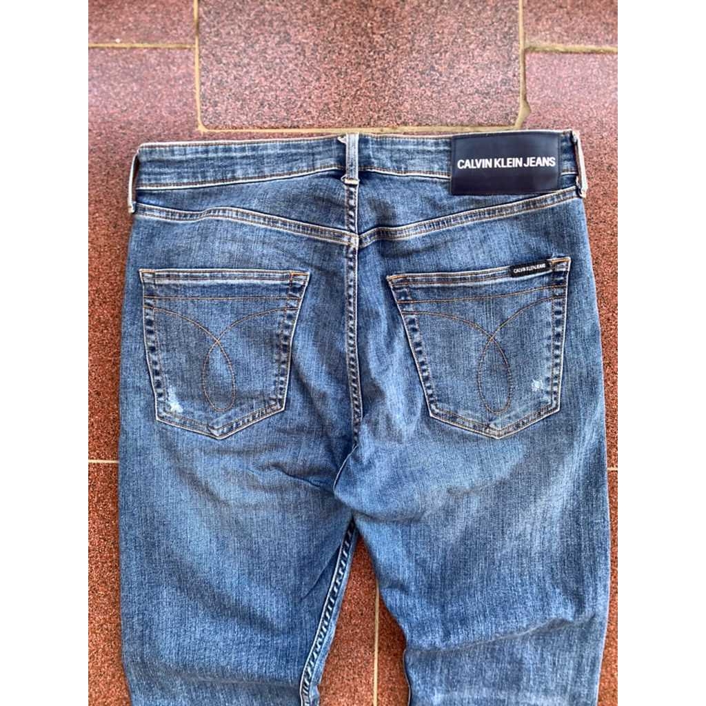 [preloved] celana jeans wanita / pria blue biru ripped full tag slimfit calvin klein jeans second - 