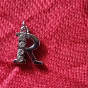 liontin putih huruf R