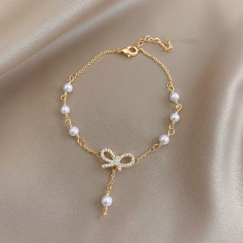 Roselife Gelang Tangan Gaya Korea Aksen Pita + Mutiara + Zircon Warna Gold Untuk Perhiasan Wanita