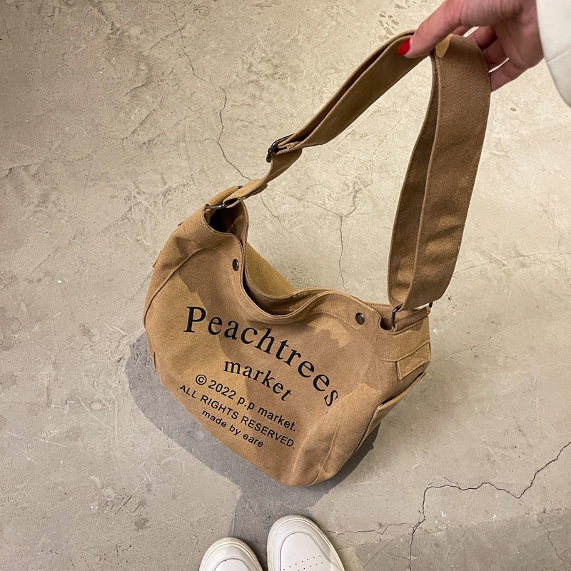 Sera import tas slempang fashion cewek tas wanita selempang bahan kanvas tas wanita selempang lebar elizabethTas Besar Gaya Mahasiswa Kelas Messenger Tas Baru Huruf Jepang Tas Kain All-Match Tas Bahu Tide