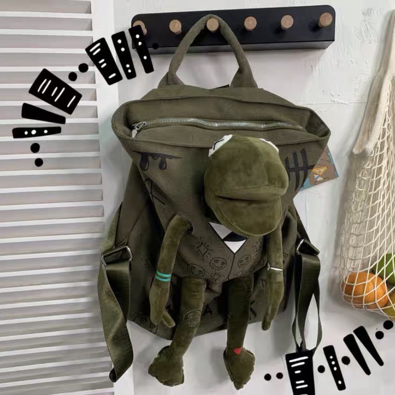 ○▦Sera Jepang Street Tide Keren Gaya Grafiti Seri Kanvas Ransel Gaya Hong Kong Sastra Katak Tide Merek Tas Sekolah Boneka