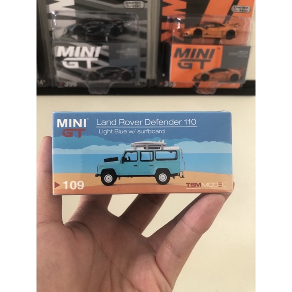 Diecast 1:64 MGT 109 Mini GT Land Rover Defender 110 - Light Blue w/ Surfboard