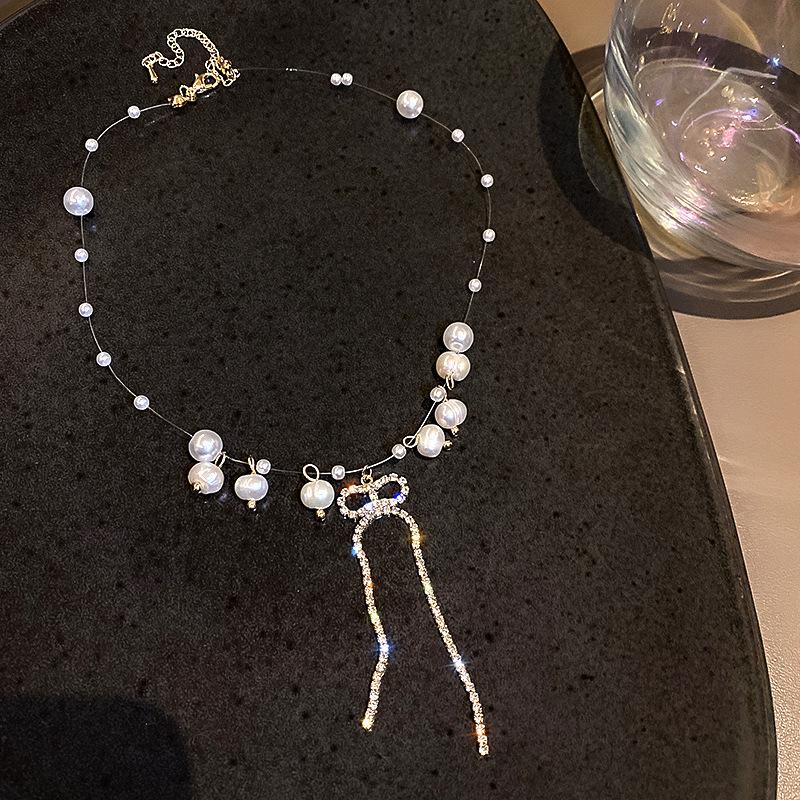 Kalung Mutiara Rantai Transparan dengan Liontin Pita Kristal