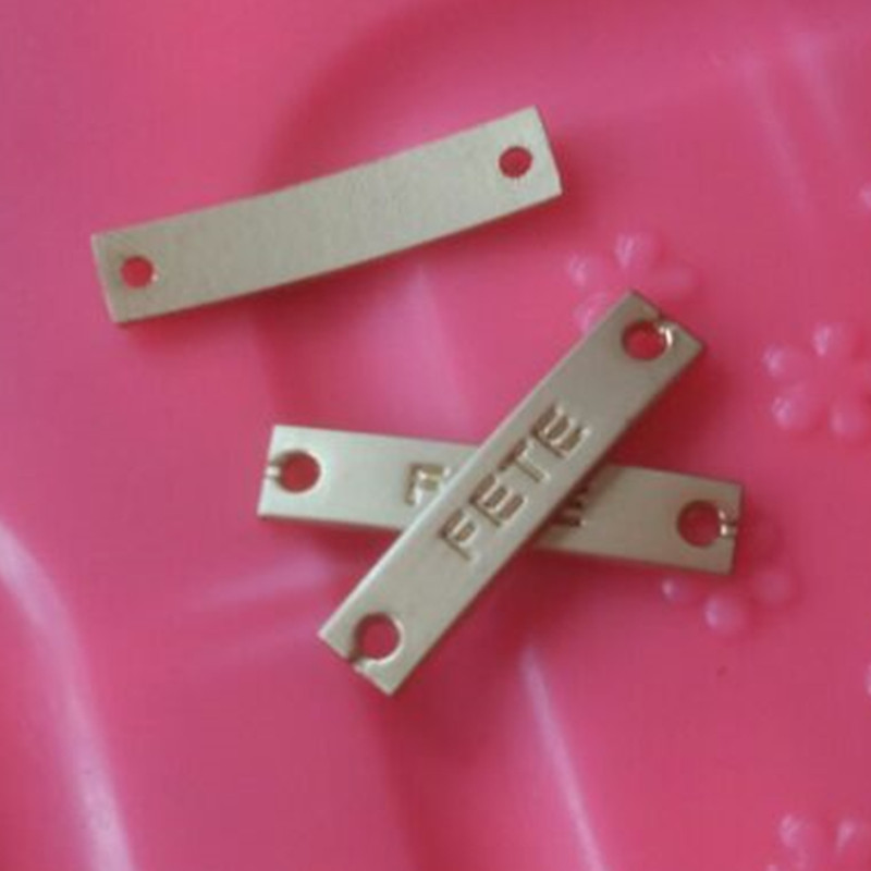 

1000PCS Custom light golden hand sewing Metal label emboss name two holes 2.5 * 0.6 cm Garment Labels