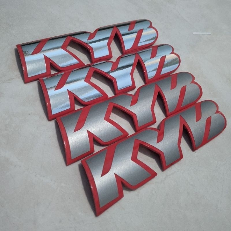 EMBLEM KYB SHOCK DEPAN LIST MERAH 1SET