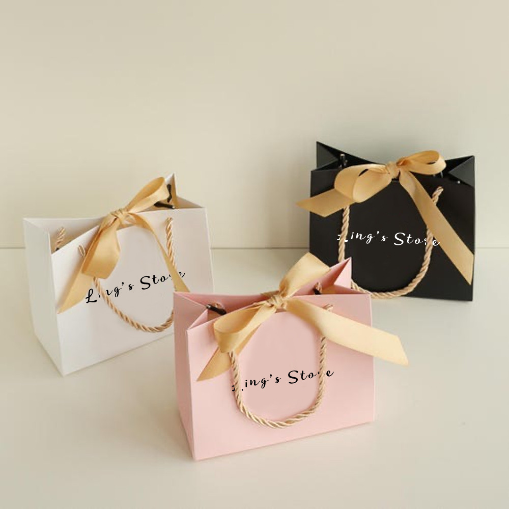 

50/100Pcs Custom Logo 14x6x12cm Jewelry Paper Handle Bag Bowknot Ribbon Wedding Gift Organizer Folder Handbag Cosmetic Packaging
