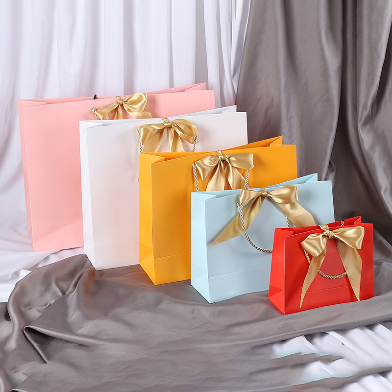 

Wholesale Paper Gift Bags with Ribbon Bow Recycled Wedding Shopping Bags with Handles Clothing Cosmetic Jewelry Packaging Bags