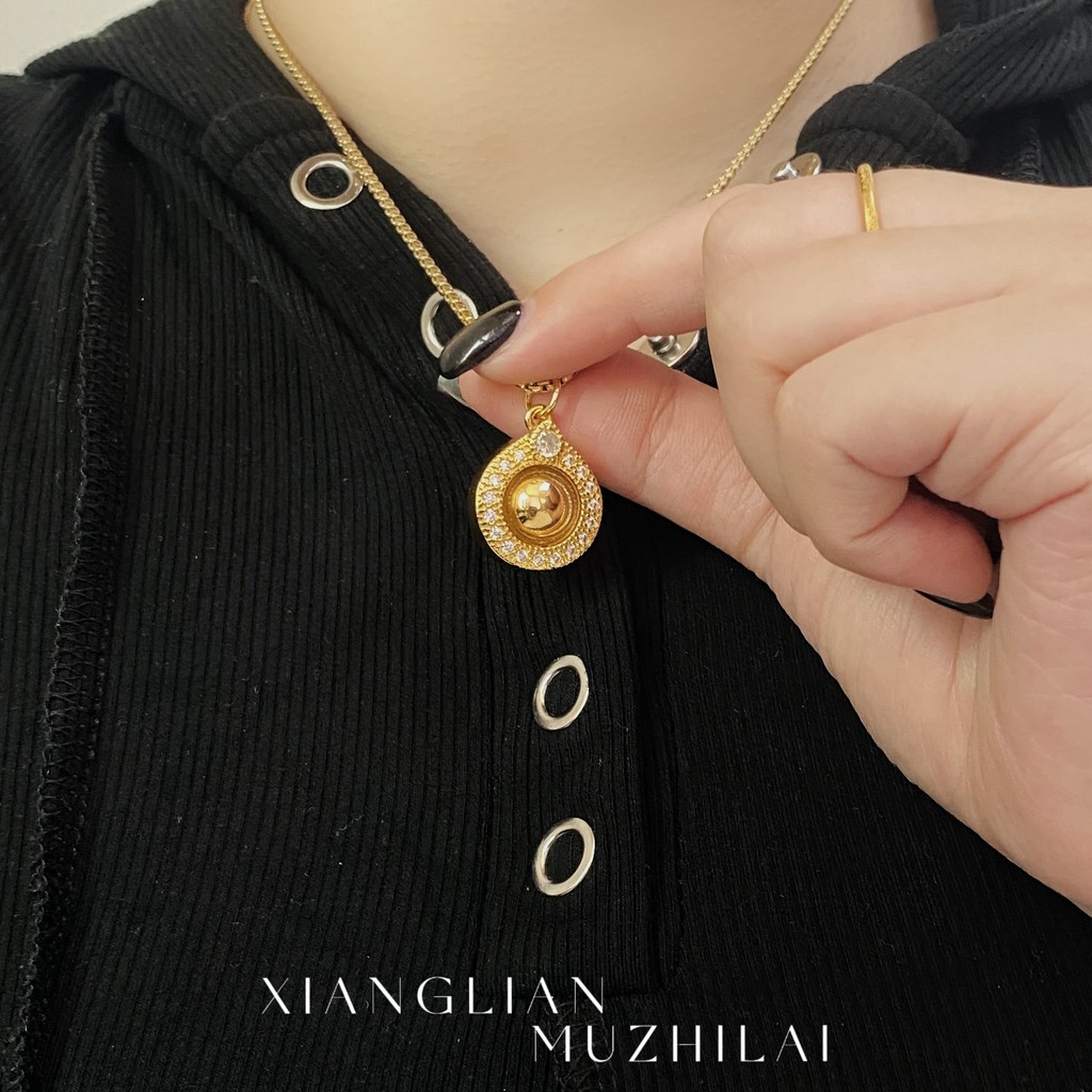Kalung wanita bertahtakan berlian dengan jimat keberuntungan untuk menarik kekayaan.