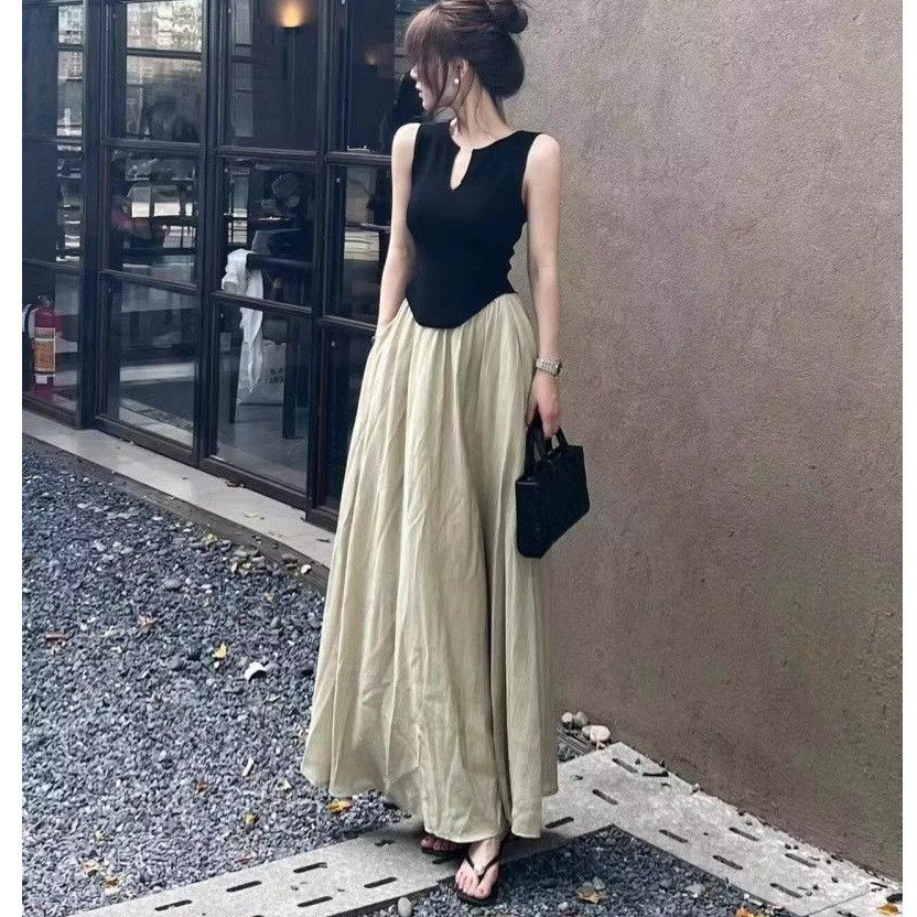 Atasan tanpa lengan yang stylish dan elegan dengan potongan lebar dan rok panjang yang jatuh, satu s