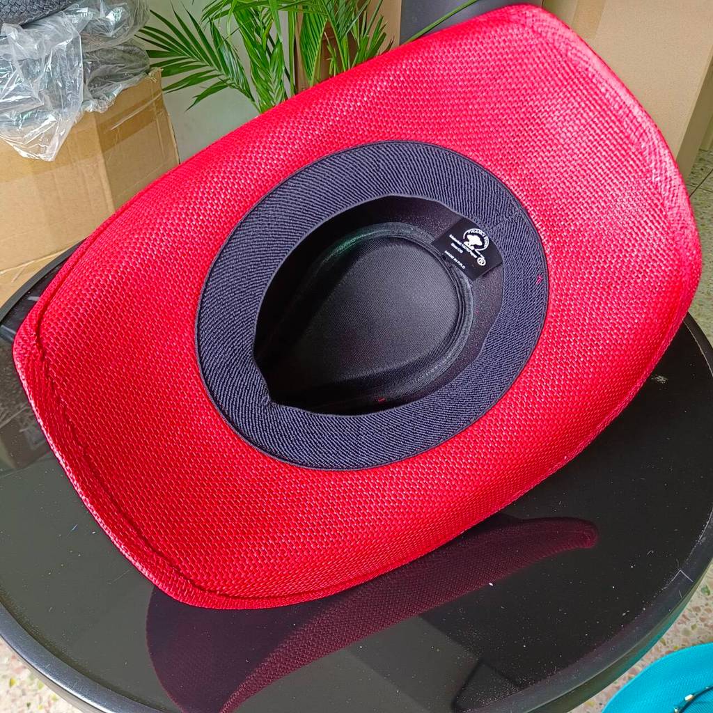 Red western cowboy hat featuring a brown hat band adorned with a studs and pendant Long-horned Ox