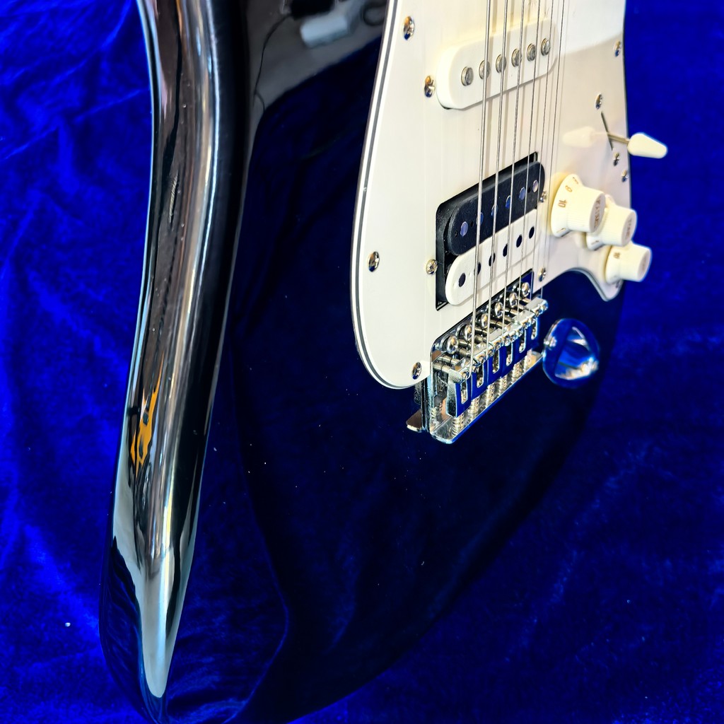 The black 6-string electric guitar with a distinctive Musicool logo on the knobs, with a split